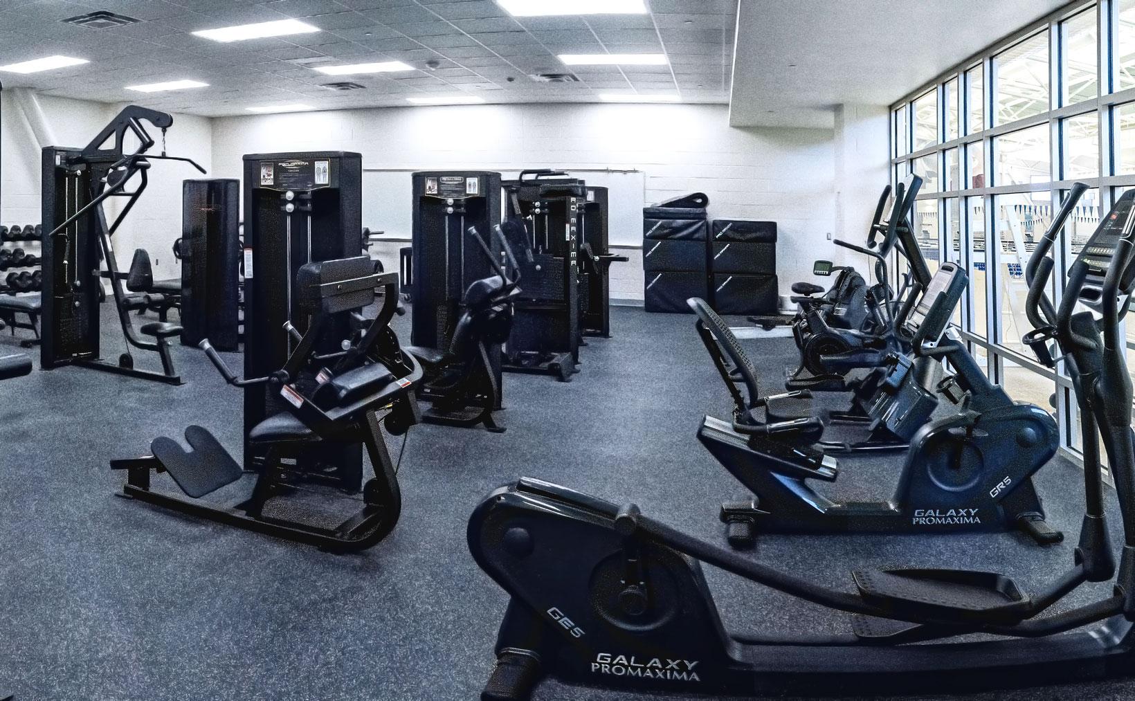 A workout room with elliptical machines and more